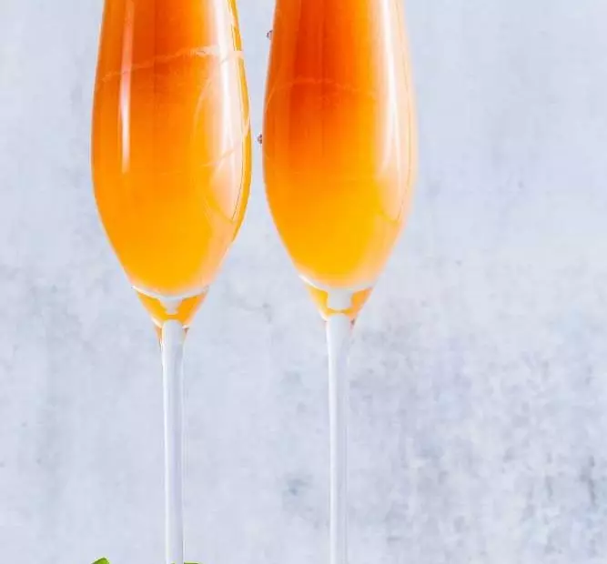 Mimosa mit granatapfel im langen Glas